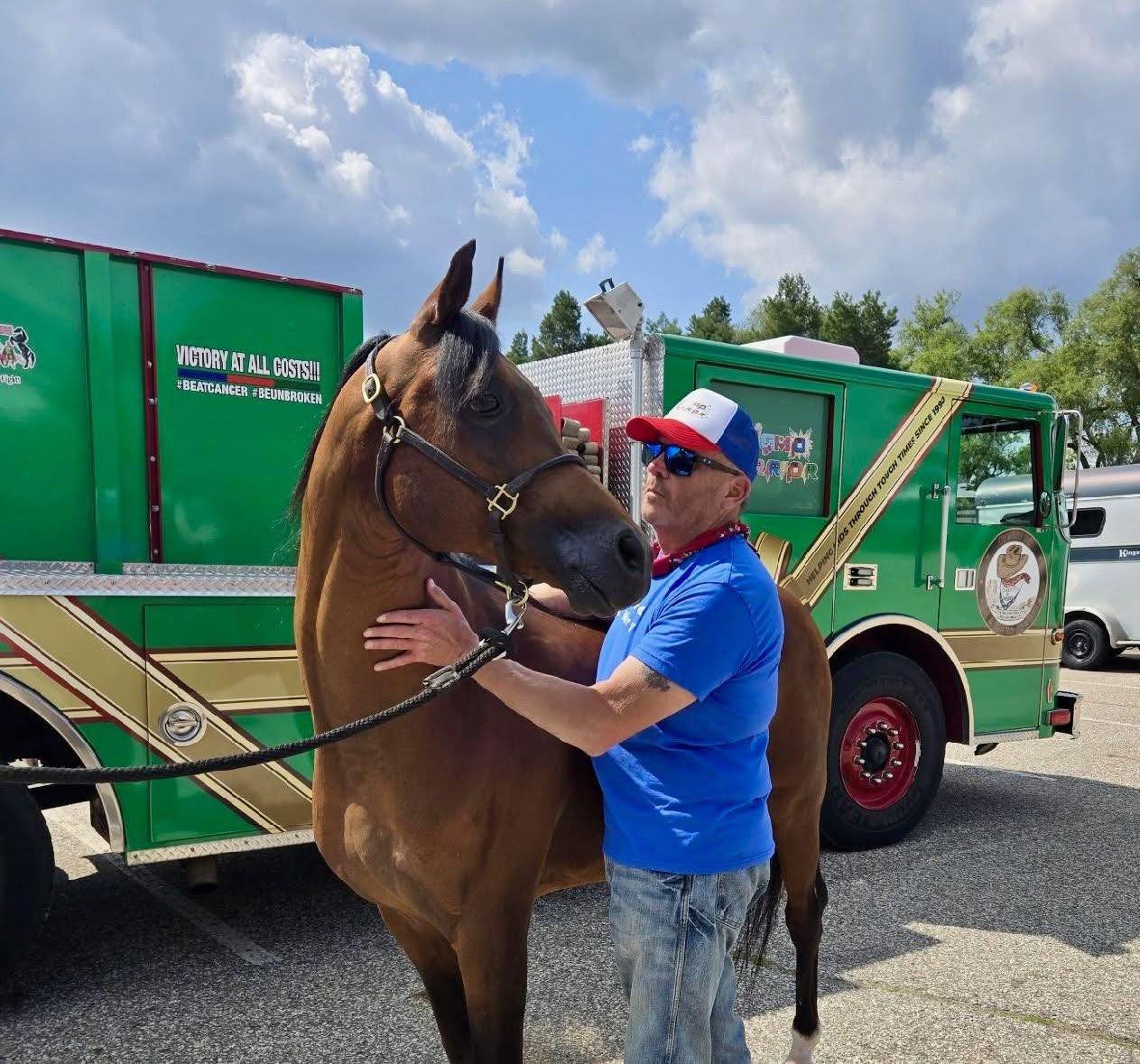 Gayelord and Marco in front of a green Santa's First Responders fire engine. 